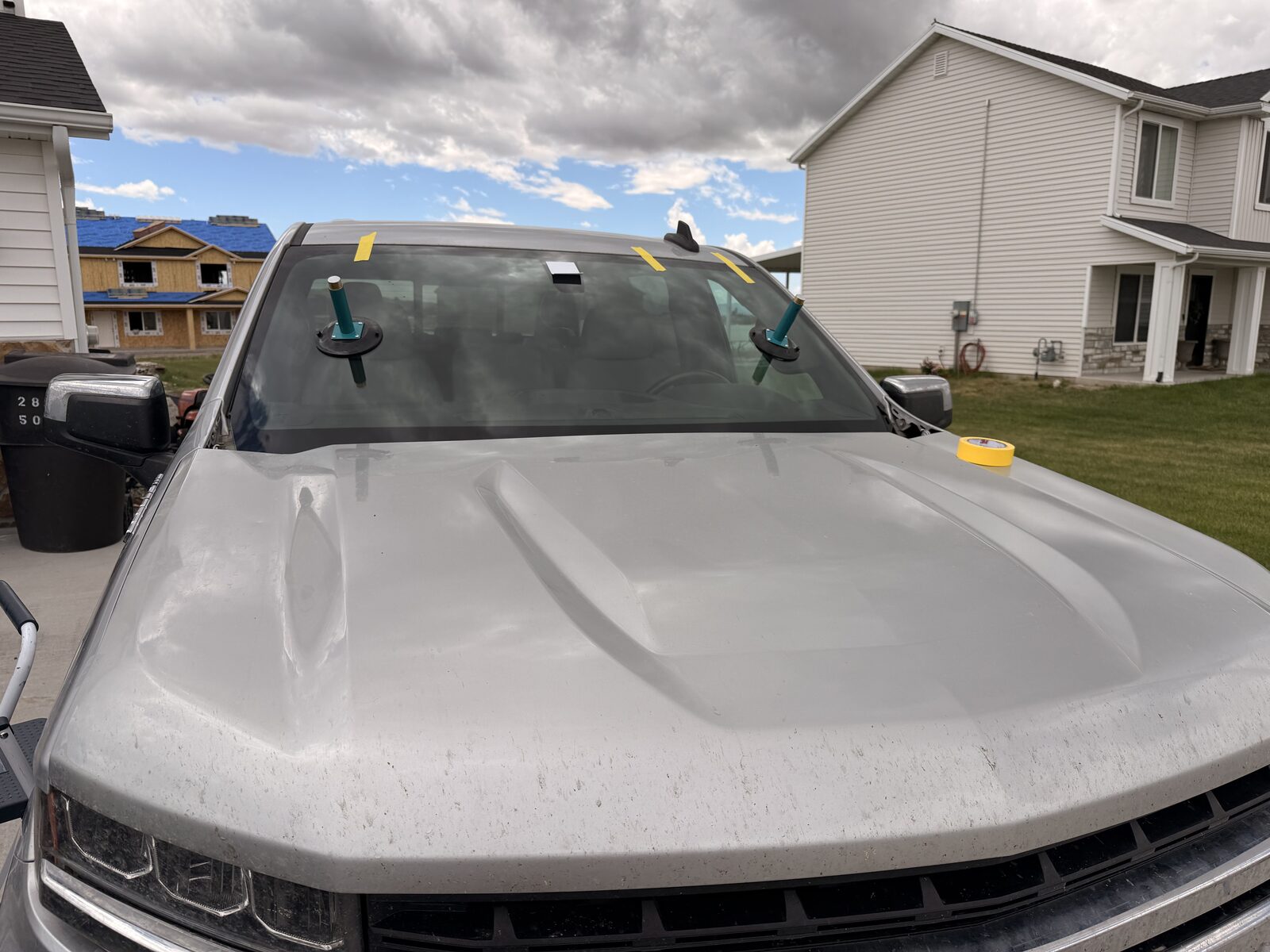 Fresh windshield set and taped while the urethane cures — mobile driveway install.